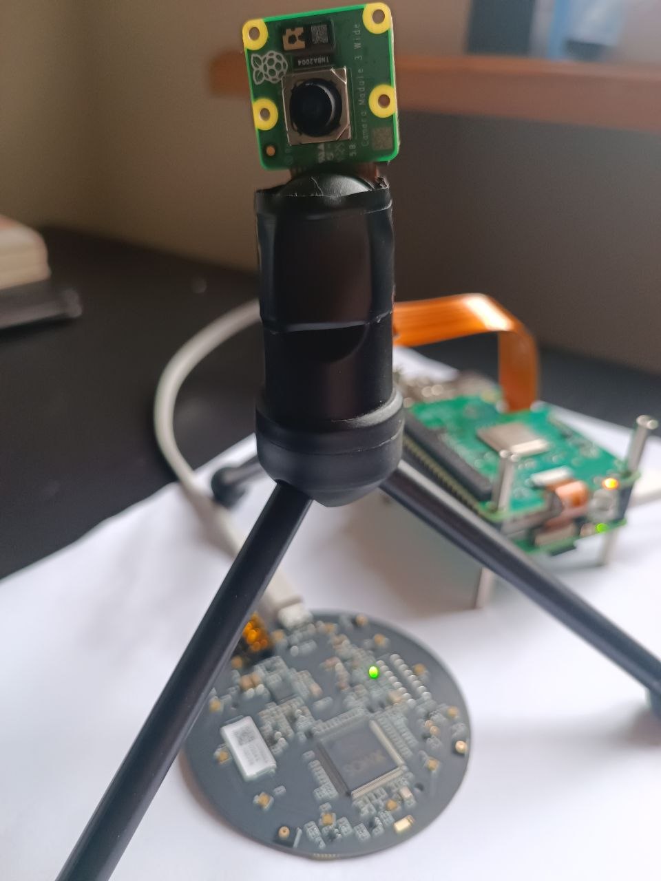 Sensor node prototype: Raspberry Pi camera module, acoustic array PCB, and compute board on the bench